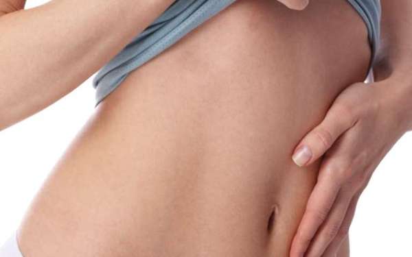 Abdominoplastia en España - Mujer mostrando su abdomen plano y firme, luego de realizarse una cirugía estética de abdominoplastia