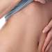 Abdominoplastia en España - Mujer mostrando su abdomen plano y firme, luego de realizarse una cirugía estética de abdominoplastia
