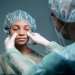 Clínicas de rinoplastia en España - Doctor comenzando a tratar la zona de la nariz de una paciente femenina, para realizar la cirugía de rinoplastia y mejorar su estética