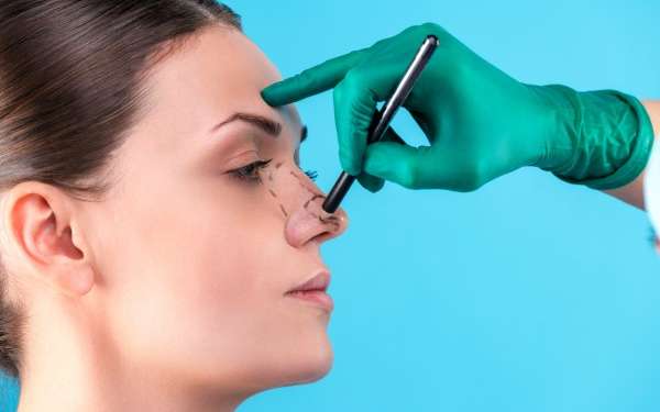 clínicas de rinoplastia en Las Palmas - cirujano dibujando la líneas para realizar una rinoplastia en Las Palmas en la nariz de una mujer