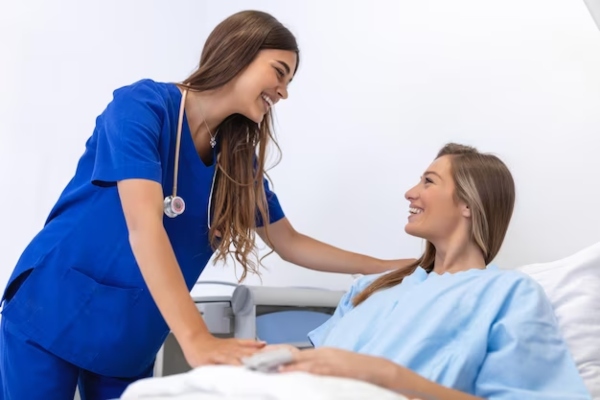 clínicas de abdominoplastia en Las Palmas - mujer tumbada en la cama de la clínica después de una abdominoplastia siendo atendida por la cirujana plástica