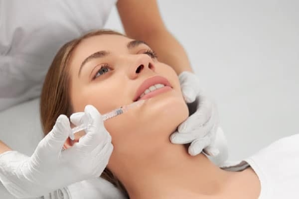 Las mejores clínicas de aumento de labios sin cirugía en Barcelona - Dermatóloga especializada en medicina estética aplica una serie de microinyecciones para aumentar el volumen de los labios de una paciente