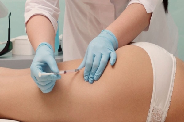 mujer recibiendo inyecci{on en el gluteo