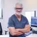 Doctor en rinoplastia en Barcelona - Perfil del Dr. Barceló Colomer con lentes y ropa de trabajo desde su consultorio