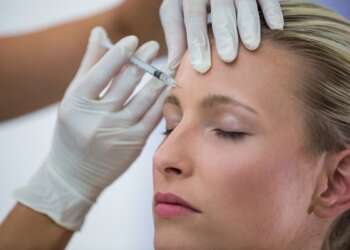 Mejores clínicas de bótox en Madrid - Médico especialista aplicando una inyección de bótox Madrid en el rostro de una mujer para eliminar las arrugas
