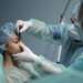 Clínicas de rinoplastia en Bilbao - Médico especialista realiza el boceto de la rinoplastia a una mujer joven en un quirófano