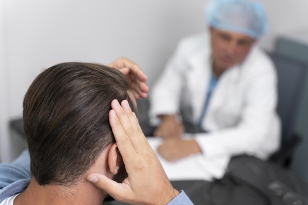 Clínicas de injerto capilar en Cataluña - Paciente en una consulta con el tricólogo, para conocer más sobre el trasplante de cabello