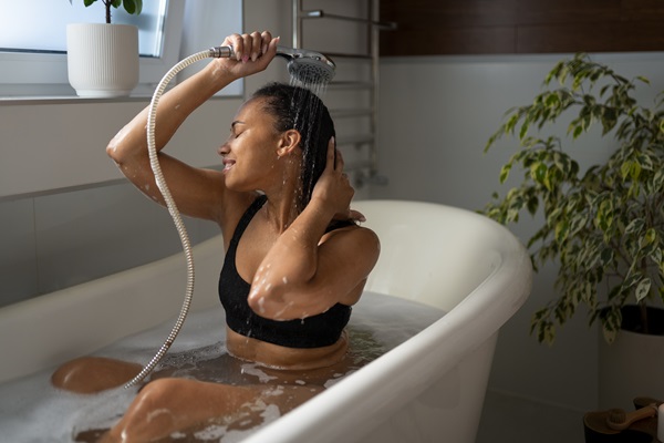 Mujer lavando su cabello en una tina, eliminando la suciedad y devolviéndole el brillo natural