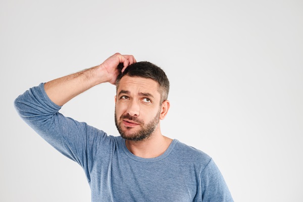 Cuántos pelos tenemos en la cabeza - Hombre pensativo porque está perdiendo pelo de manera más frecuente, lo cual puede ser un síntoma de alopecia
