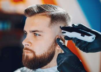 Cortes de pelo en el hombre - Estilista realizando un corte de cabello a un hombre según la forma de su rostro, para crear un look más atractivo