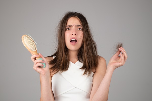 Mujer abrumada por la pérdida de cabello que está presentando debido al estrés