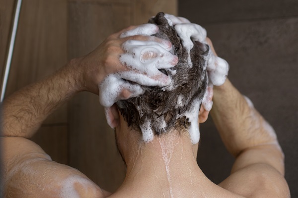 Ketoconazol champú - Hombre lavando su cabello con un champú que posee Ketoconazol, para eliminar la caspa