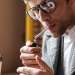 Fumar aumenta la caída del pelo - hombre joven encendiendo un cigarrillo en una cafeteria