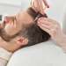 Mesoterapia capilar tratamiento - Dermatóloga inyecta un cóctel de vitaminas para estimular el crecimiento del cabello en un hombre
