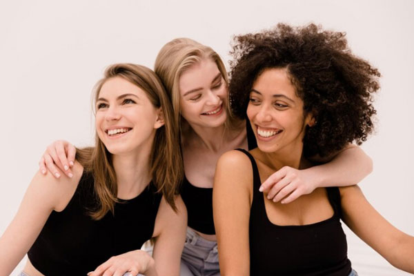 Kit para el cuidado del cabello - Tres mujeres con distintos tipos de cabello posan felices frente a la cámara