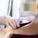 Psoriasis capilar, causas, síntomas y tratamiento - dermatólogo revisando la piel de los hombros y cuello de una paciente
