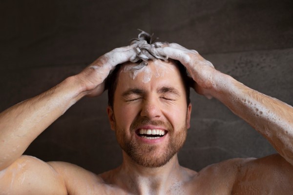 cuidar el pelo en los hombres - hombre en la ducha enjabonándose el cabello