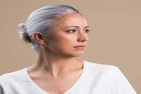 envejece nuestro pelo - mujer con claros signos del envejecimiento de su cabello al tener el cabello con canas