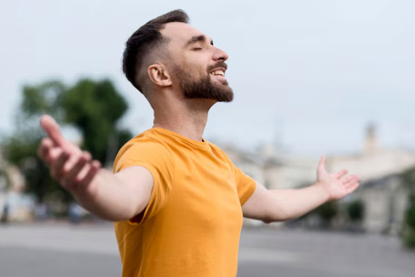 Salud mental en el hombre - Hombre feliz con los brazos abiertos sale a relajarse al aire libre