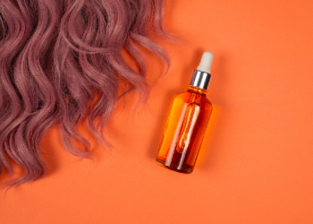 aceite de ricino para el pelo - cabellos al lado de un recipiente con aceite de ricino