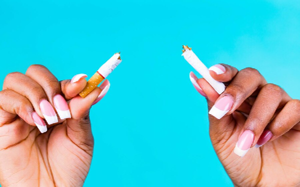 dejamos de fumar engordamos - Plano detalle de las manos de una mujer morena rompiendo un cigarrillo