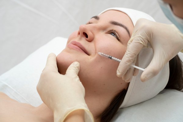 mesoplastia - mujer en la consulta de la especialista sometiéndose a un tratamiento facial en inyección