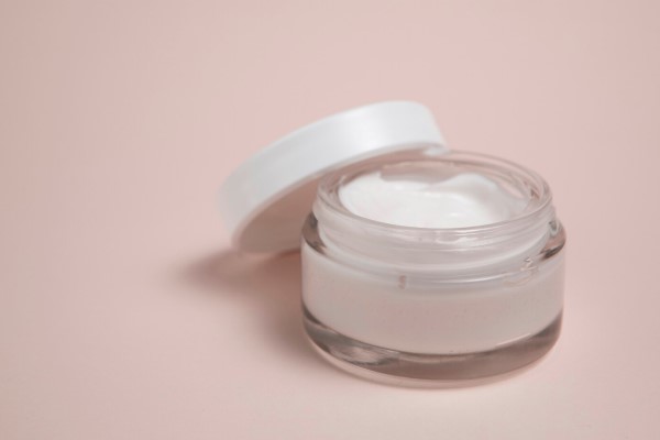 Para qué sirve el ácido hialurónico - bote de crema con ácido hialurónico sobre fondo rosa