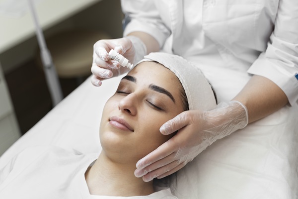 Tratamiento regenerador facial - Mujer realizándose un tratamiento de microagujas, para estimular la producción de colágeno en la piel de su rostro