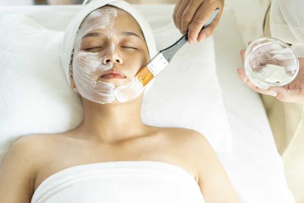 Tratamiento regenerador facial - Mujer aplicándose un peeling químico en su rostro, para eliminar las células muertas de la piel