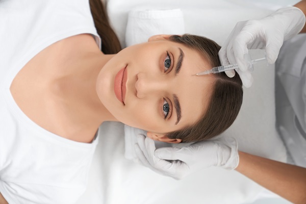 Mujer aplicándose una inyección de botox en el rostro, para reducir las arrugas y líneas de expresión