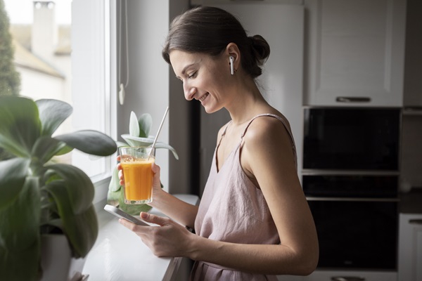 Mujer ayunando con un juego de naranja, el cual ayuda a absorber mejor los suplementos vitamínicos