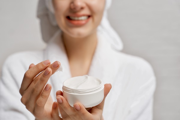 Mujer aplicando una crema rejuvenecedora en el rostro, para hidratar la piel y eliminar las arrugas