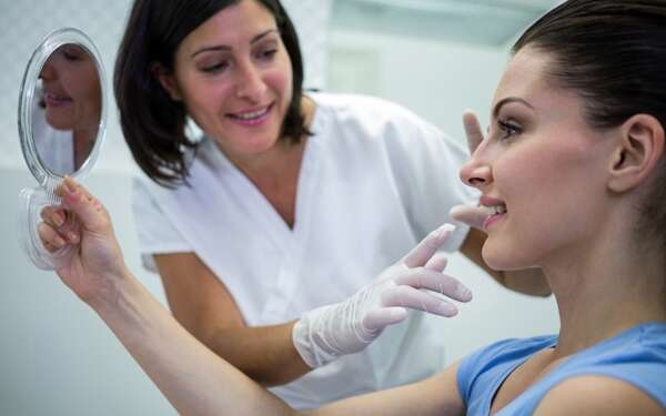 Ácido hialurónico Barcelona - Esteticista evaluando el rostro de una mujer para determinar el precio ácido hialurónico en la mejor clínica estética Barcelona