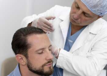 Mejores clínicas trasplantes capilares - Médico tricólogo realizando un tratamiento capilar a un hombre en una de las mejores clínicas injerto capilar Madrid