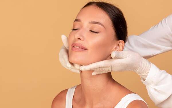 Relleno de mentón - Médico estético de la mejor clínica ácido hialurónico Madrid evaluando a una paciente luego del tratamiento de relleno de mentón