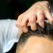 Injerto capilar España - Tricólogo evaluando el cabello de un hombre luego de un implante capilar con los mejores doctores injerto capilar España