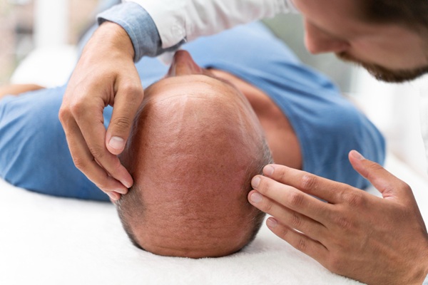 Doctor evaluando a un hombre con alopecia avanzada para realizar un tratamiento capilar en la mejor clínica implante capilar Madrid